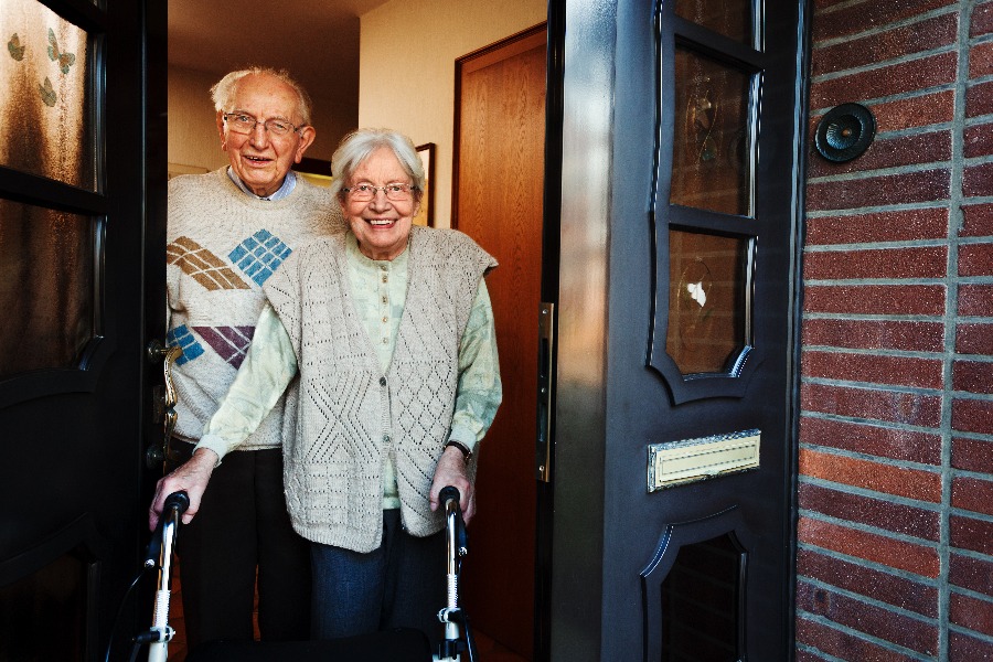 elderly couple opening the front door